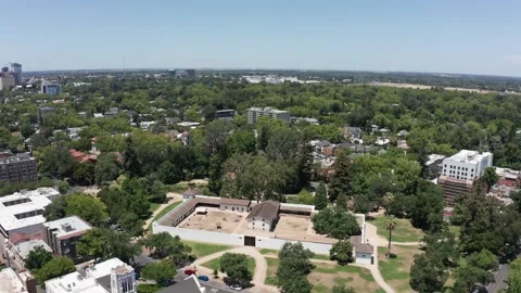 Wide panning aerial shot of Sutter's Fort with Downtown Sacramento in the Stock Footage 201983953