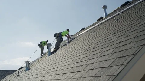Wide panning low angle shot of workers installing rails on roof / Mapleton, Stock Footage 77469163
