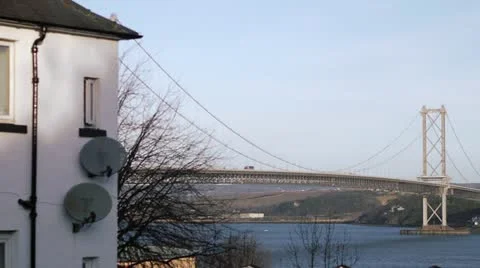 Wide panning shot of Forth Bridges with house Stock Footage 21887647