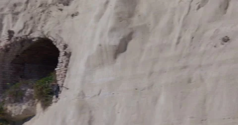 Wide panning shot right to left white cliffs of Dover with a brick lined tunnel 動画素材 329761670