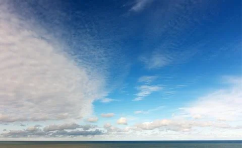 Wide Panorama of a Dramatic Blue Sky with Contrasting Clouds Over the Sea 02 Stock-Fotos