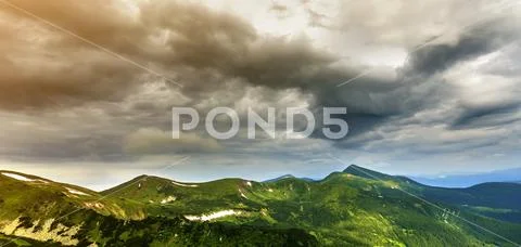 Wide panorama of lit by morning sun green valley, hills covered with forest a Stock Photos