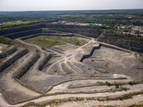 Wide panoramic aerial view of active terraced open pit granite stone quarry.. Stock Photos