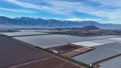 Wide panoramic shot over a vast agricultural valley covered in greenhouse Vídeos de archivo 340381634