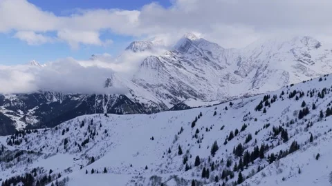 Wide panoramic shot of the snow-covered slopes and dramatic peaks of the Mont Stock Footage 346672496