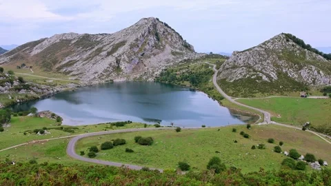 Wide panoramic view of alpine lake Covadonga and mountain range Picos de Europa Stock Footage 339960601
