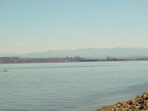 Wide panoramic view of the calm blue sea and distant hills under a soft summe 写真素材