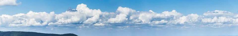 Wide panoramic view on group of clouds on a sunny, summer day. Stock Photos