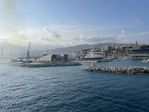 Wide panoramic view of the harbor of Genoa. Blue sky blue sea white clouds and Stock Photos