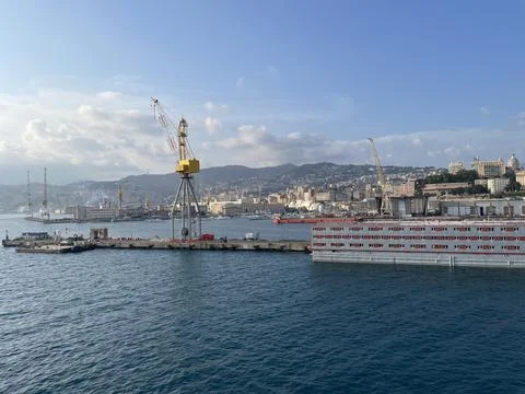 Wide panoramic view of the harbor of Genoa. Blue sky blue sea white clouds and Stock Photos