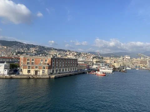 Wide panoramic view of the harbor of Genoa. Blue sky blue sea white clouds and Stock Photos