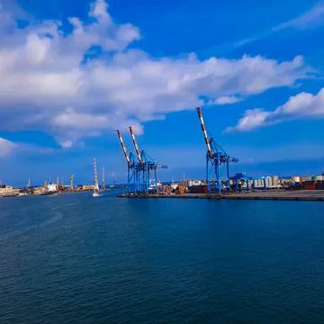 Wide panoramic view of the harbor of Genoa. Blue sky blue sea white clouds and Stock Photos
