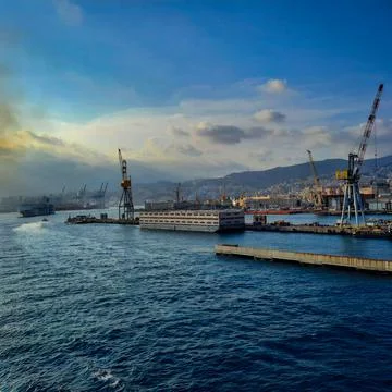 Wide panoramic view of the harbor of Genoa. Blue sky blue sea white clouds and Stock Photos