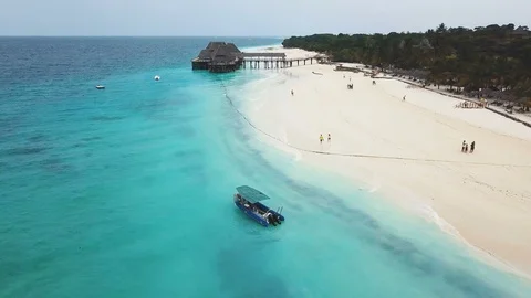 Wide paradise beach with white sand, azure ocean and sailing boat on cloudy day Stock Footage 91800575