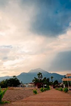 Wide path leads through  garden area as clouds form over  mountain in the dis Stock-Fotos