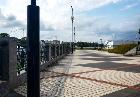 Wide paved public square with linear perspective of streetlights Stock Photos