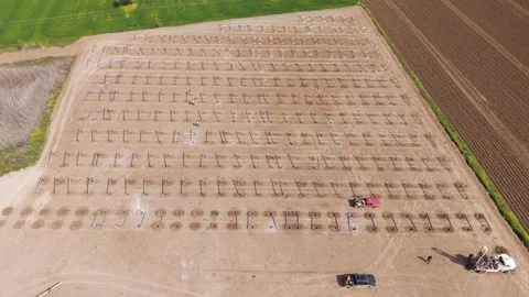 Wide pull out shot of solar mounting stands beside grass field Stock Footage 332548255