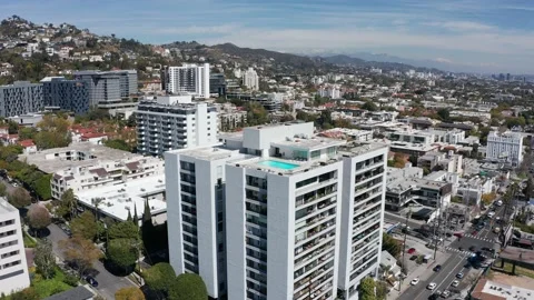 Wide push-in aerial shot of a rooftop pool on top of a condo tower in West Stock Footage 237501632