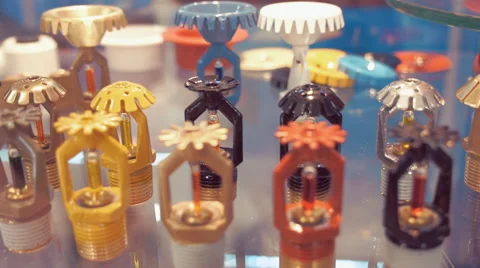 A wide range of fire sprinklers, different colors and sizes, on the glass shelf Stock Footage 64736879