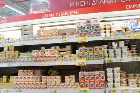 Wide range of processed cheese on shelves of supermarket. Choice of milky goo Stock Photos