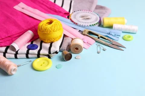 A wide range of sewing materials and tools is located on a colored background Stock Photos