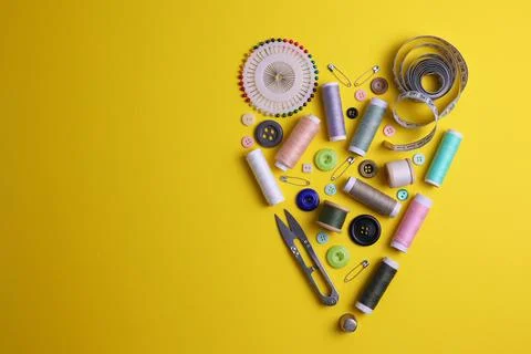 A wide range of sewing materials and tools is located on a colored background Stock Photos