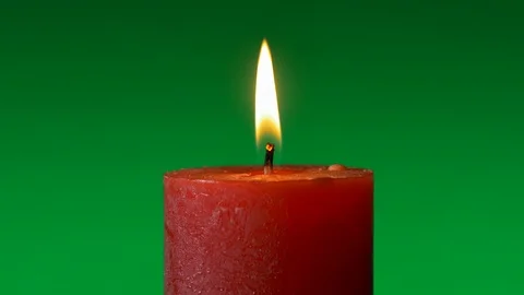 Wide red candle stable flame on green background Stock Footage 122864545