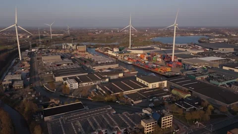 Wide reverse aerial context of wind turbines and port area Stock Footage 335658628