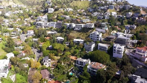 Wide reverse pullback aerial shot of homes on the hills above the Sunset Vídeo Stock 237523089