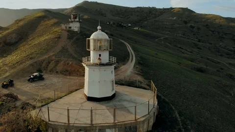 A wide reverse spin aerial view of the lighthouse and surrounding rocky cliffs Stock Footage 123220972