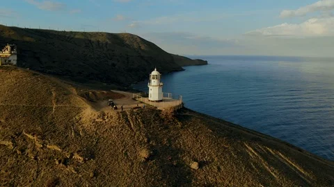 A wide reverse spin aerial view of the lighthouse and surrounding rocky cliffs Stock Footage 123223011