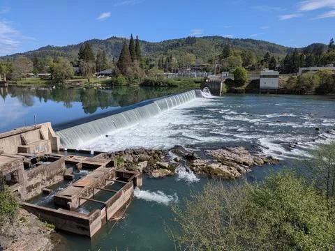 Wide river and roaring rapids flowing beside a fish ladder and dam Stock Photos