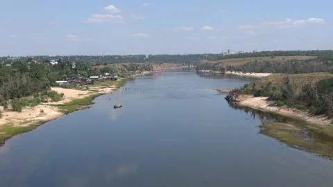 A wide river between sandy banks, rocks, and greenery Stock Footage 340358366