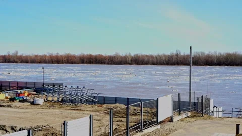 Wide river with floating ice blocks near a construction site Stock Footage 332434344