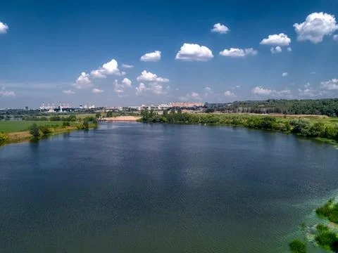 Wide river flowing between fields Stock Photos