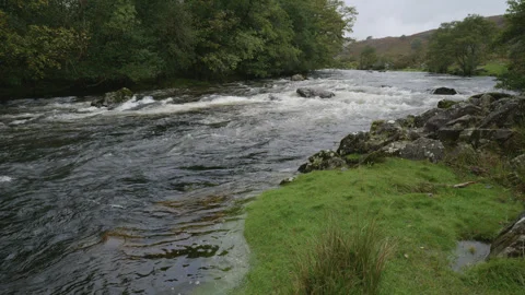 A wide river is flowing fast over rocks - close up - Lake District UK. 4K tripod Stock Footage 252521047