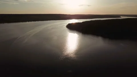 Wide river is flowing at sunset in the summer. Sun's rays are reflecting Video stock 95898984