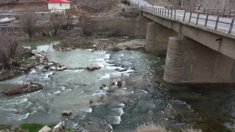 Wide river flowing under a large asphalt bridge, stock footage. Stock Footage 304784406