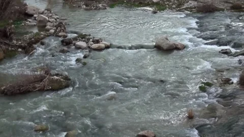 A wide river flows beneath a large asphalt bridge its, stock footage. 스톡 동영상 304784412