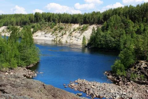 A wide river flows between sandy beaches surrounded by a mixed coniferous for Stock Photos