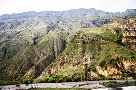 A wide river at the foot of high cliffs. Stock Photos