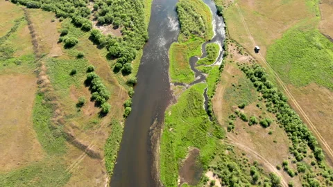 Wide river surrounded by meadows and trees near ground road with driving car, Stock Footage 139860743