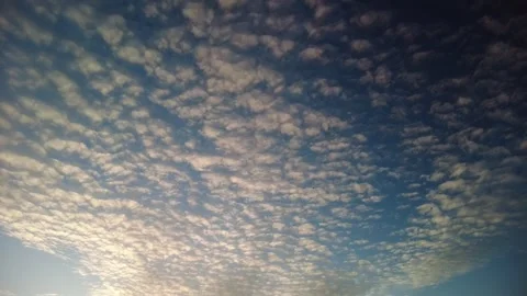 A wide river of tiny white clouds on a blue background meets and sails overhead Stock Footage 273740333