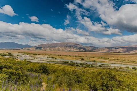 Wide River Valley Under Dramatic Mountain Clouds Foto stock