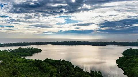 Wide river view with cloudy sky and green trees Stock Photos