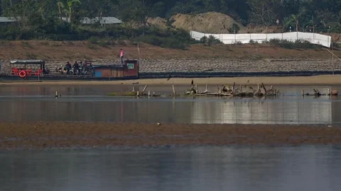 Wide river view with distant people and wooden posts in water Stock Footage 327179697