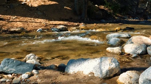 Wide river water flow on the rocks on a sunny day. Mud. Slow motion Video stock 105404549