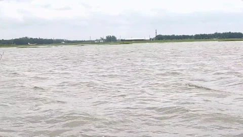 Wide River with Waves and Rural Shoreline Under Overcast Sky Stock Footage 341882081