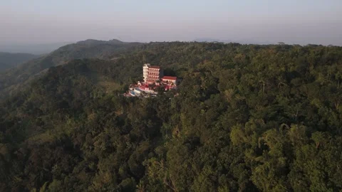 Wide rotating aerial view of hotel perched on top of a hill in a forest. Stock Footage 293597339