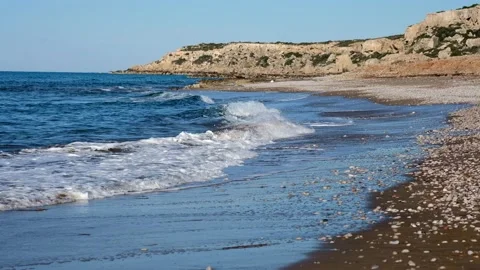 Wide sand beach and rolling sea waves with white thick foamy crests under blue Stock Footage 153797925